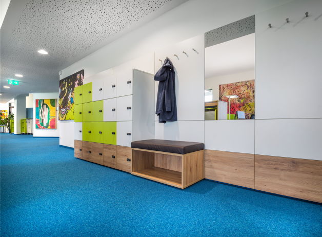 Durchdachtes Garderobensystem mit Sitzmöglichkeit, Spiegel und farblich abgesetzten Spinden bei Risk Experts